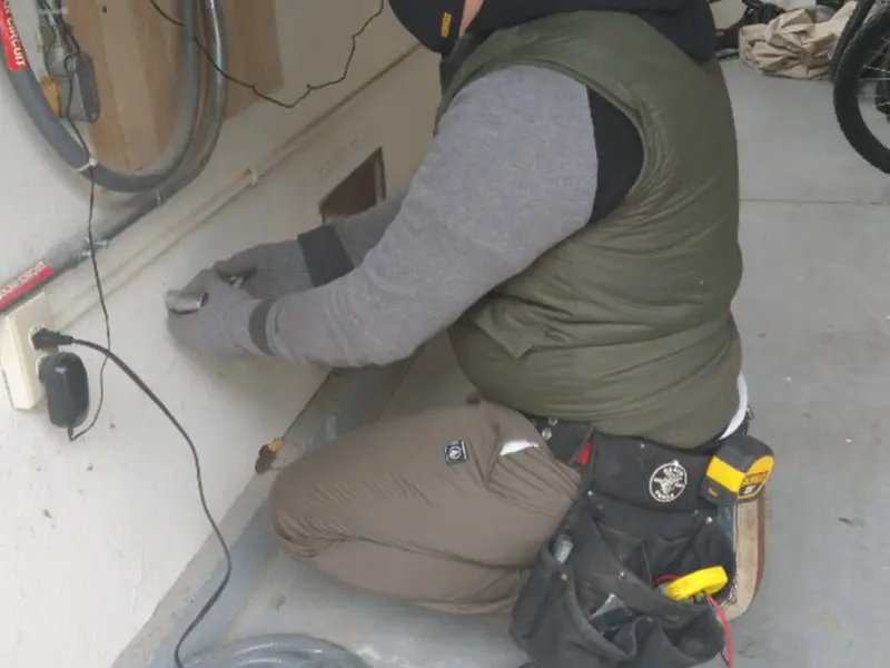Electrician performing outlet wiring in a Cleveland garage